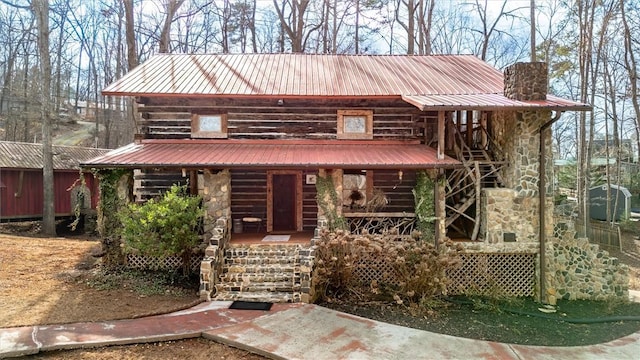 124-130 S Port Bass Dr, Fair Play, SC 29643 - view of front facade featuring covered porch, metal roof, stone siding, stairs, and a chimney