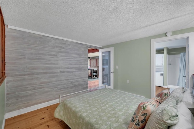 124-130 S Port Bass Dr, Fair Play, SC 29643 - bedroom featuring an accent wall, a textured ceiling, baseboards, and wood finished floors