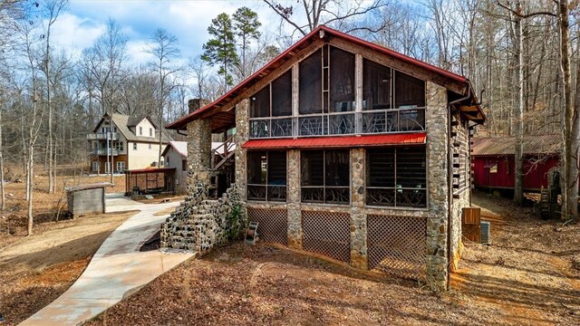 124-130 S Port Bass Dr, Fair Play, SC 29643 - rear view of house featuring stone siding and a sunroom