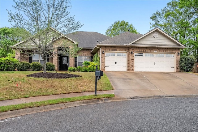 view of front of home featuring brick siding, a front yard, a garage, and concrete driveway