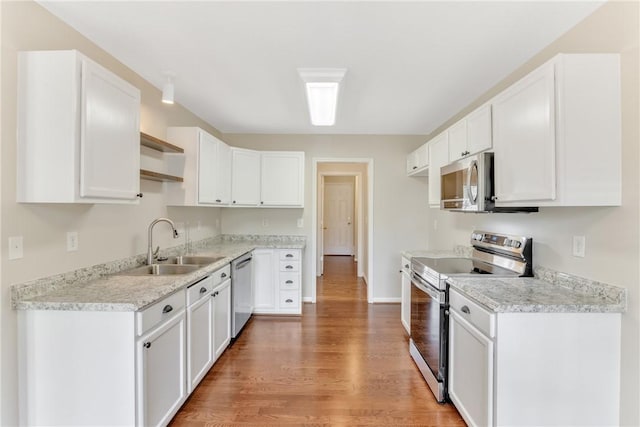 kitchen with open shelves, white cabinets, appliances with stainless steel finishes, and light wood-style floors
