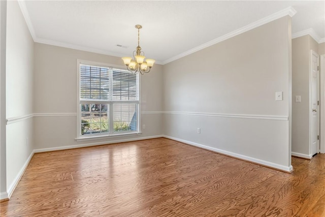 unfurnished room featuring wood finished floors, a notable chandelier, and ornamental molding