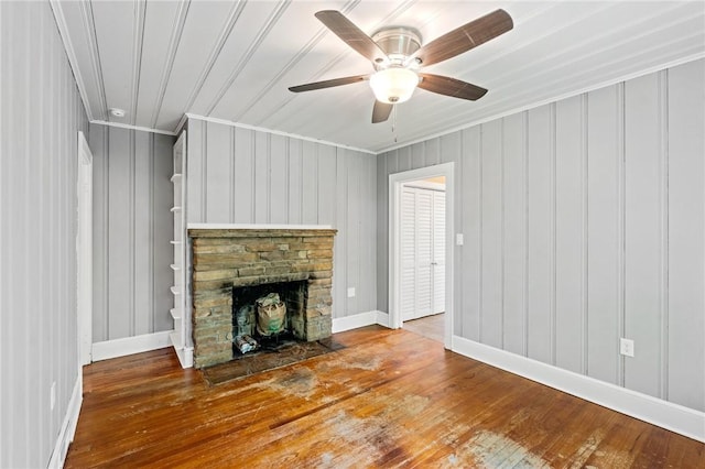 unfurnished living room with baseboards, ornamental molding, a fireplace, a ceiling fan, and hardwood / wood-style flooring