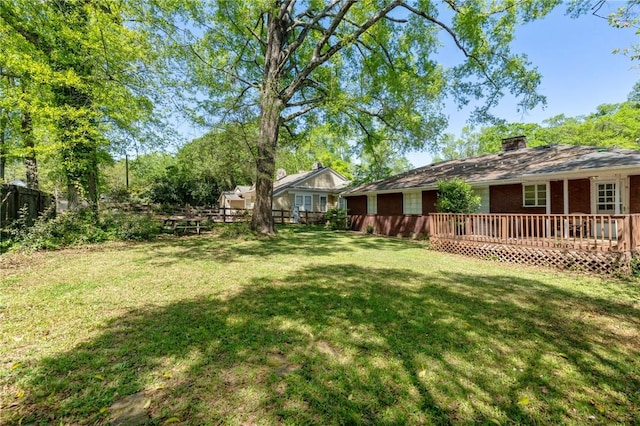 view of yard with a deck and fence