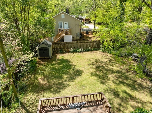 view of yard with a shed, an outdoor structure, and fence