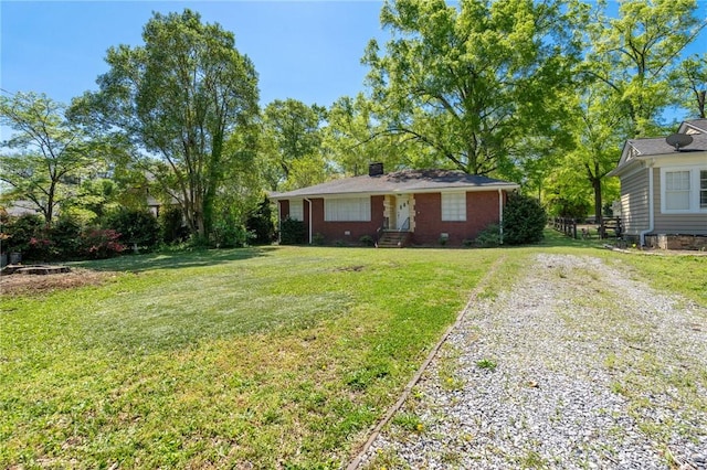 view of front facade featuring driveway, a chimney, and a front lawn