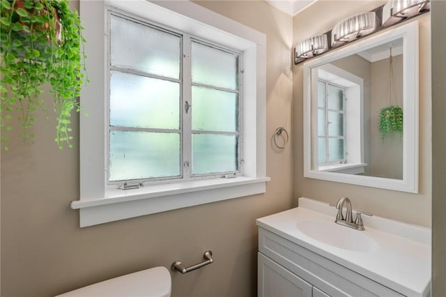 bathroom with plenty of natural light, vanity, and toilet