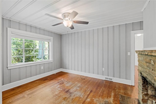 empty room featuring baseboards, ceiling fan, wood-type flooring, and visible vents