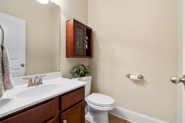 bathroom with tile patterned flooring, toilet, vanity, and baseboards