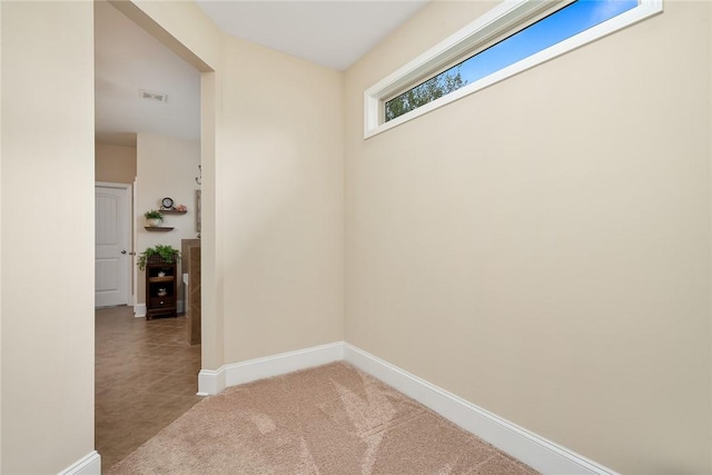 corridor with visible vents, baseboards, and carpet floors