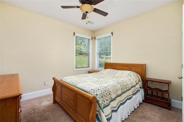 bedroom with light colored carpet, baseboards, and a ceiling fan