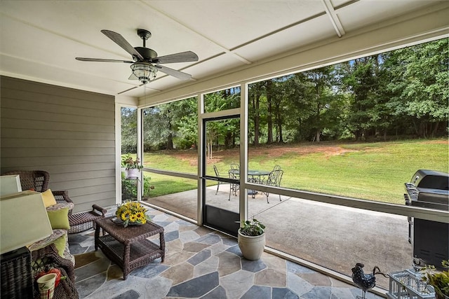 unfurnished sunroom featuring a ceiling fan