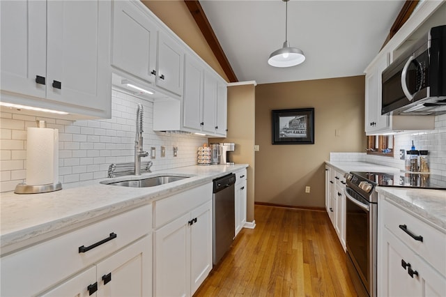 kitchen featuring tasteful backsplash, baseboards, white cabinets, a sink, and stainless steel appliances