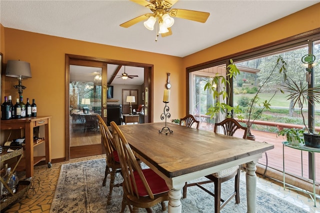 dining space with baseboards and ceiling fan