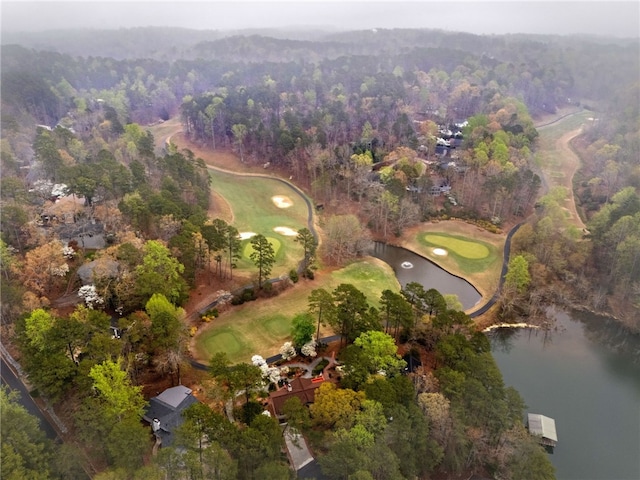 bird's eye view featuring a wooded view, golf course view, and a water view