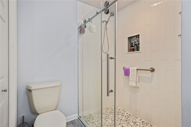 bathroom featuring toilet and a stall shower