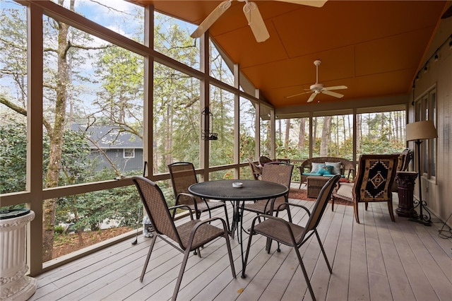 sunroom with a ceiling fan, outdoor dining space, and a healthy amount of sunlight