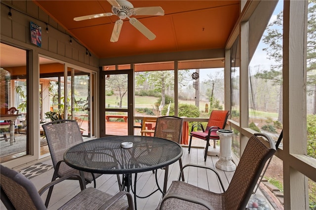 sunroom with a ceiling fan, outdoor dining area, and a healthy amount of sunlight