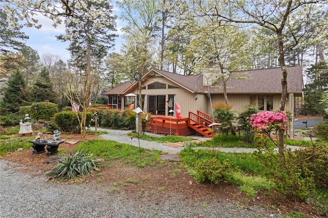 back of house with a wooden deck and roof with shingles