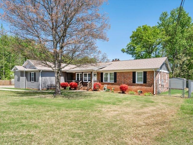 ranch-style home with a gate, fence, and a front lawn