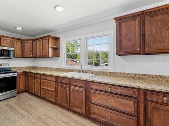 kitchen featuring tasteful backsplash, a sink, stainless steel appliances, light wood finished floors, and ornamental molding