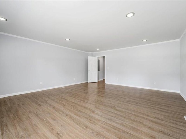 empty room with crown molding, recessed lighting, wood finished floors, and baseboards