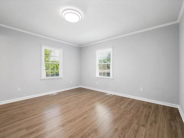spare room with ornamental molding, a wealth of natural light, and dark wood-style flooring