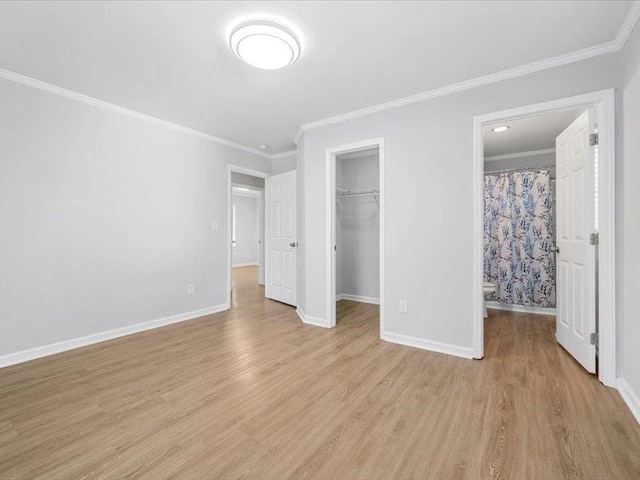 unfurnished bedroom with baseboards, crown molding, and light wood-style flooring