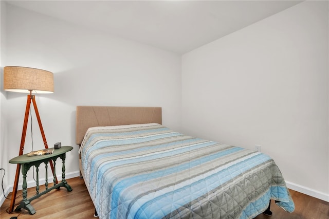 bedroom featuring baseboards and wood finished floors