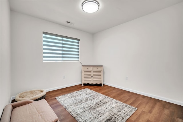 sitting room featuring visible vents, baseboards, and wood finished floors