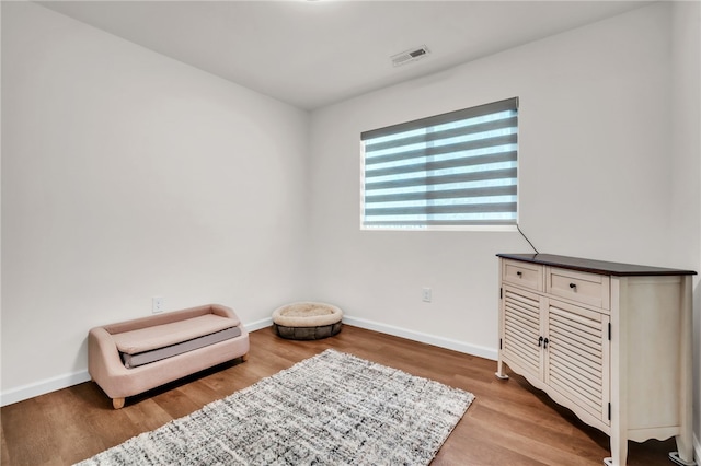 sitting room featuring wood finished floors, baseboards, and visible vents