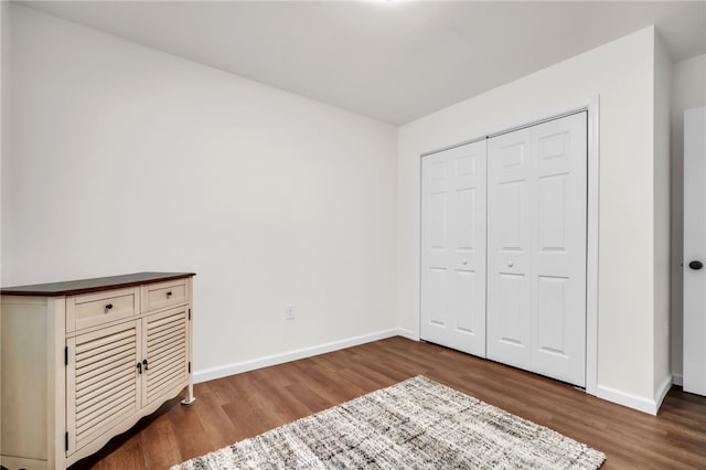 unfurnished bedroom featuring wood finished floors and baseboards