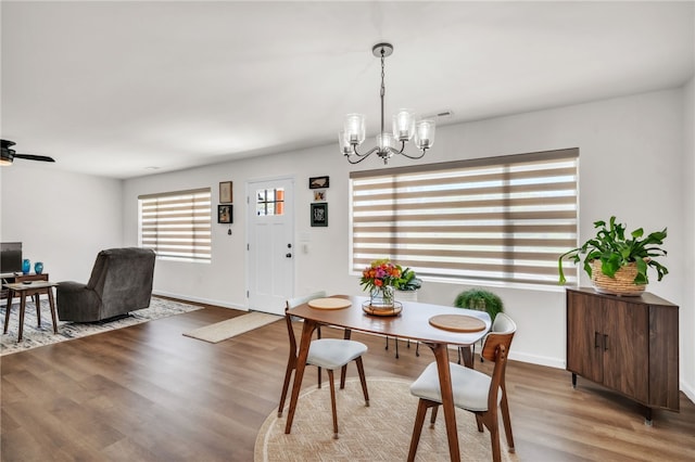 dining room featuring visible vents, baseboards, an inviting chandelier, and wood finished floors