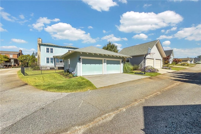 view of front facade with fence, a detached garage, and a front yard