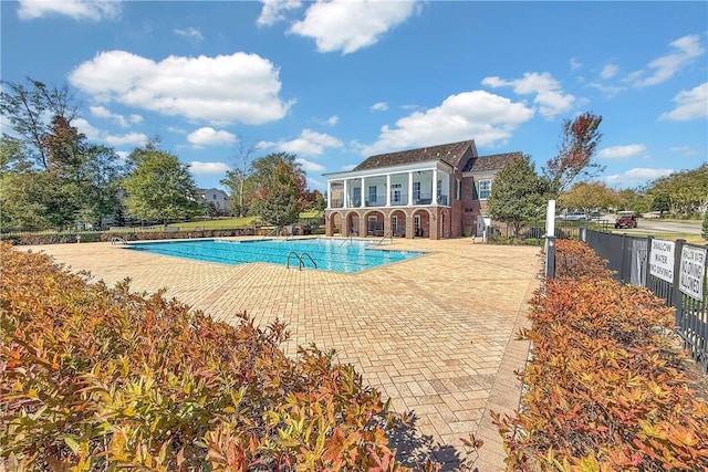 pool featuring fence and a patio area