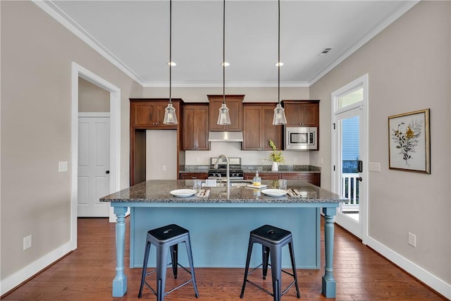 kitchen featuring a kitchen bar, visible vents, ornamental molding, and stainless steel appliances