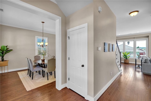 interior space featuring wood-type flooring, baseboards, and a notable chandelier