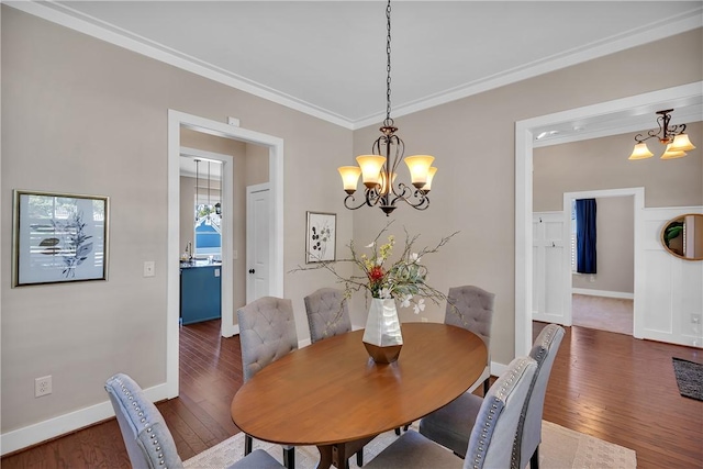 dining area featuring hardwood / wood-style flooring, baseboards, an inviting chandelier, and crown molding