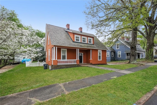 bungalow-style house with roof with shingles, a chimney, a front yard, fence, and covered porch