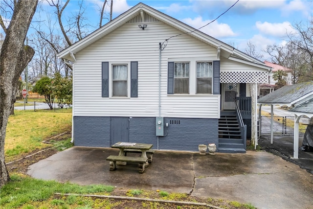 rear view of house with a patio and a lawn