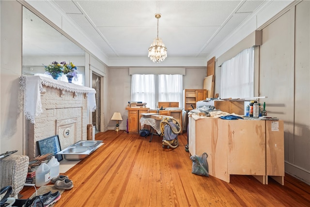 interior space with a chandelier, light wood-style floors, and ornamental molding