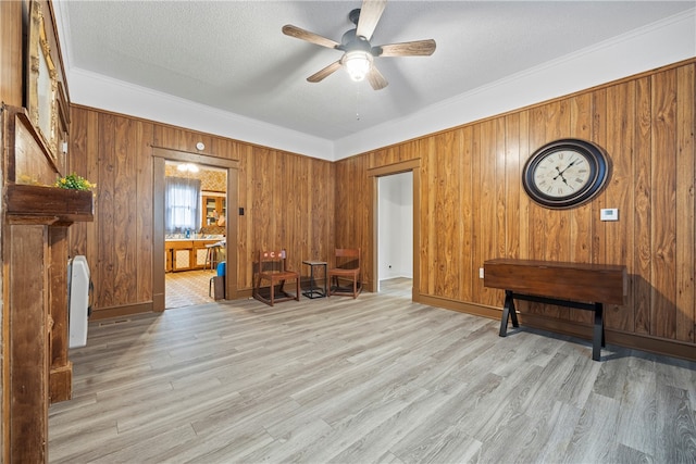 interior space featuring ornamental molding, wood finished floors, and wood walls