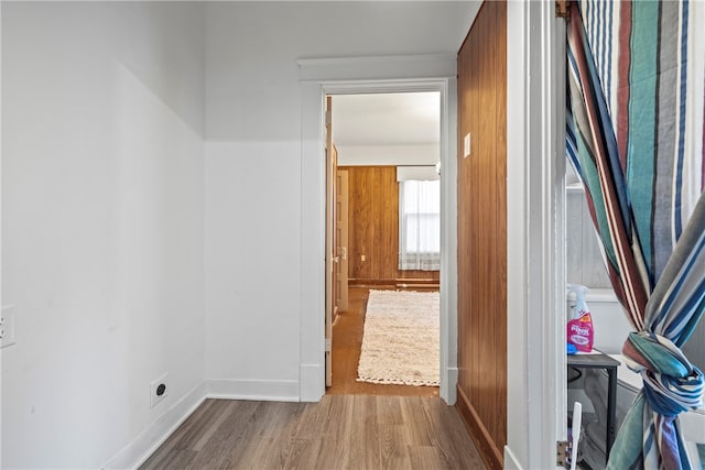 corridor with baseboards and wood finished floors