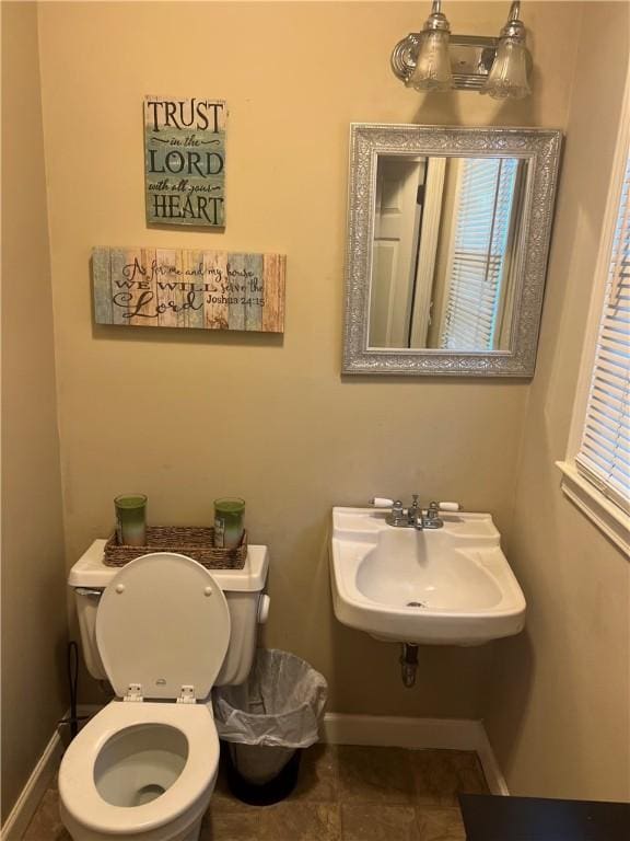 bathroom with baseboards, a sink, and toilet