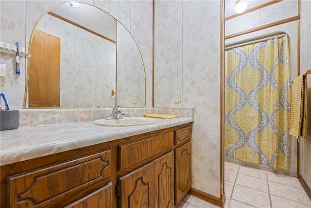 bathroom with baseboards, a shower with shower curtain, vanity, wallpapered walls, and tile patterned flooring