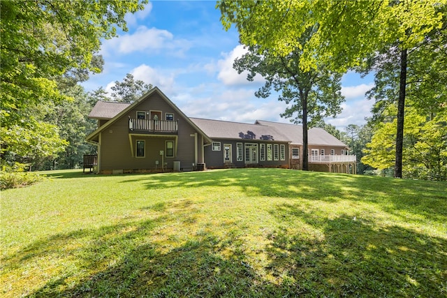 back of house with a yard and a balcony