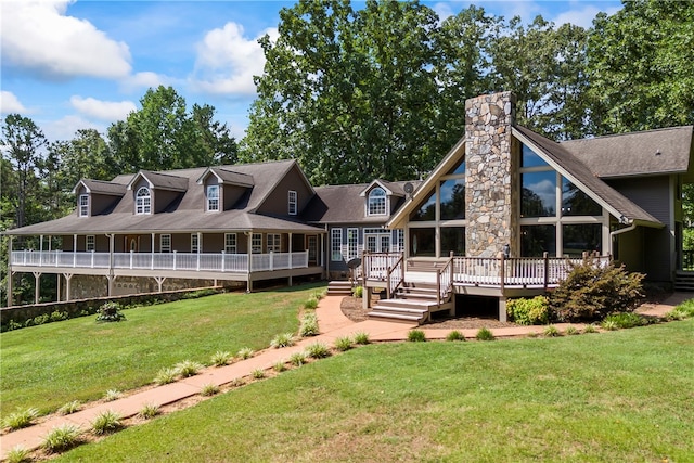 rear view of house with a deck, a chimney, and a lawn