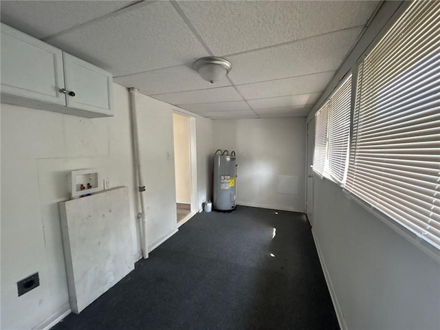 interior space with electric water heater, baseboards, and a paneled ceiling