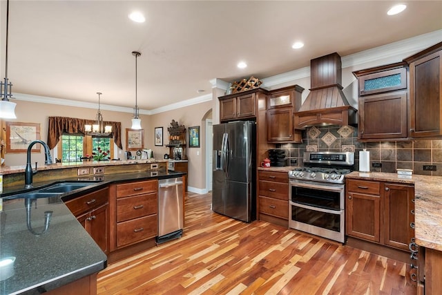 14029 Azalea Dr, Seneca, SC 29678 - kitchen featuring custom exhaust hood, appliances with stainless steel finishes, a sink, hanging light fixtures, and light wood finished floors