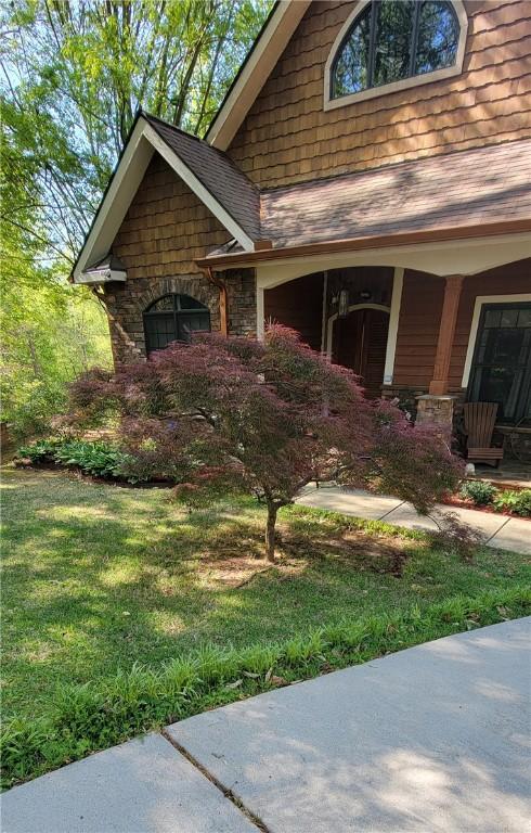 14029 Azalea Dr, Seneca, SC 29678 - view of front of home featuring stone siding, a shingled roof, and a front lawn